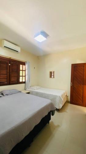 a bedroom with two beds and a window at CasaMares Macapá - Praia de Macapá in Macapá
