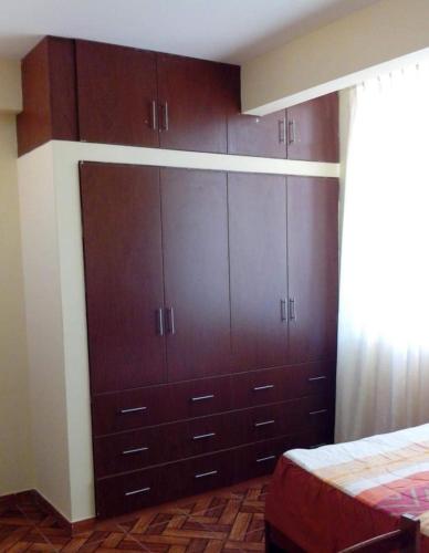 a bedroom with brown cabinets and a bed at Hotel Mi Estrella in Chimbote