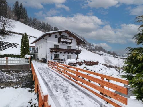a building with a fence in the snow at Anja in Zell am See