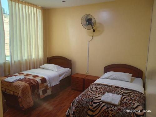 a hotel room with two beds and a fan at Hotel Mi Estrella in Chimbote