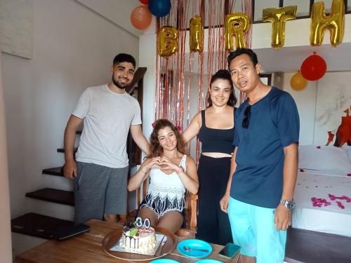 a group of people standing in front of a birthday cake at Putra Boyan Cottages in Gili Trawangan