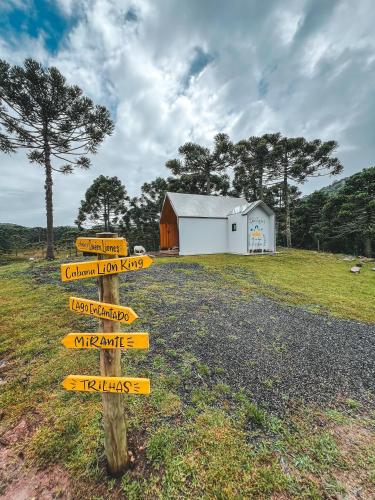 a directional sign in a field in front of a barn at Morada Reino Encantado in São Joaquim
