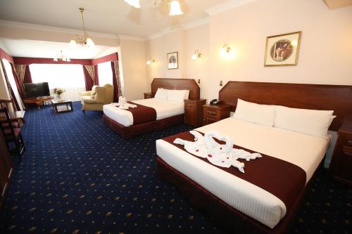 a hotel room with two beds and a living room at Palais Royale in Katoomba