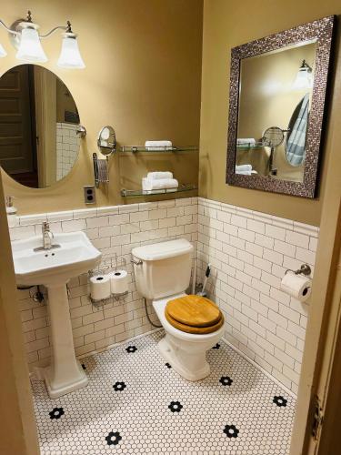 a bathroom with a toilet and a sink and a mirror at The Gibson Mansion Bed and Breakfast in Missoula