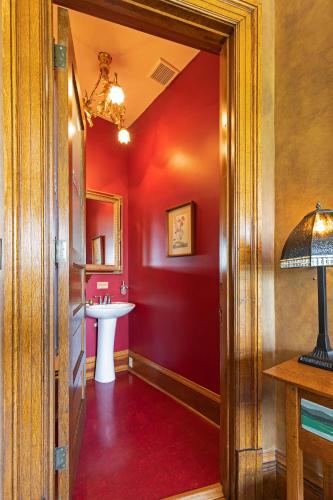 a bathroom with a sink and a red wall at The Gibson Mansion Bed and Breakfast in Missoula