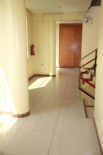 an empty hallway with a door and a tile floor at Hotel Mi Estrella in Chimbote