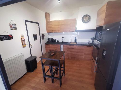 a kitchen with a small table and a refrigerator at Bel Appartement pour 1 à 9 personnes in Ambert