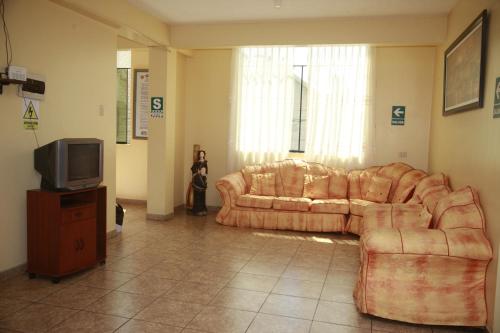 a living room with a couch and a tv at Hotel Mi Estrella in Chimbote