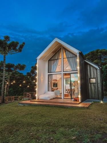 a large glass house with a bed on a deck at Morada Reino Encantado in São Joaquim