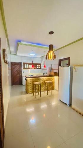 a kitchen with a refrigerator and a table and chairs at CasaMares Macapá - Praia de Macapá in Macapá