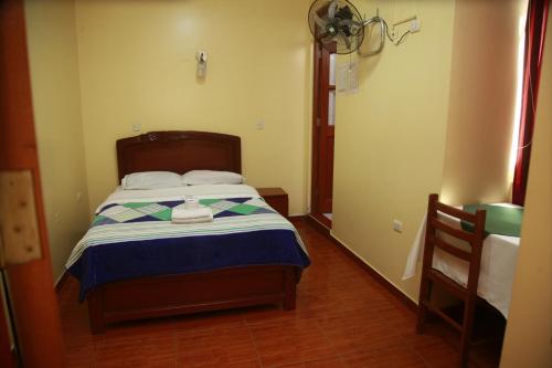 a bedroom with a bed with a blue and white blanket at Hotel Mi Estrella in Chimbote