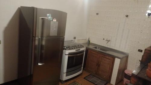 a kitchen with a stainless steel refrigerator and a stove at Casa da Cris in Campos do Jordão