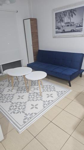 a living room with a blue couch and two tables at Acogedor departamento 1 dormitorio in El Palomar