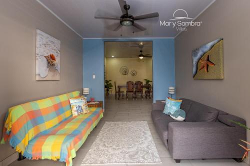 a living room with a couch and a ceiling fan at Mar y Sombra Villas in Quepos