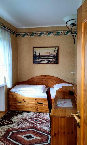 a bedroom with a wooden bed and a table at Puszczykowska willa in Puszczykowo