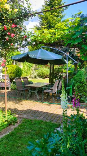 a patio with a table and chairs and an umbrella at Puszczykowska willa in Puszczykowo