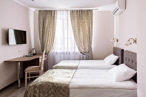 a hotel room with two beds and a desk and a window at Time Hotel in Kyiv