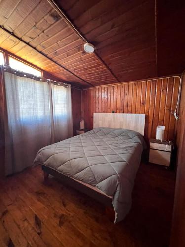 エル・キスコにあるLodge Arena y Solの木製の部屋に大型ベッドが備わるベッドルーム1室が備わります。