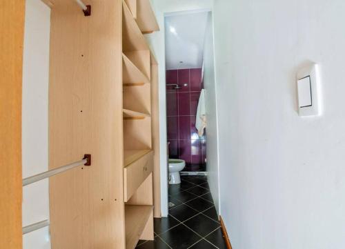 baño con aseo y armario de madera en Casa Hotel Bewell - Los colores Medellín, en Medellín