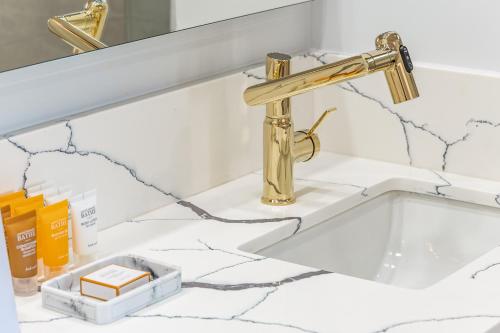 a bathroom sink with a gold faucet at 30th Fl Luxury Ocean & Waikiki view with Free Parking in Honolulu