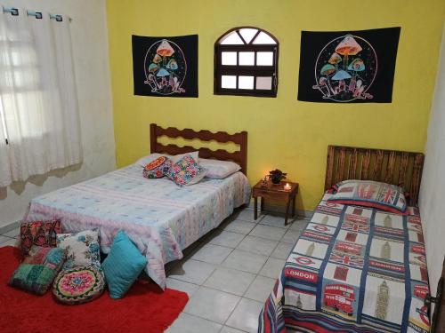 a bedroom with two beds and a window at Renovo Beija-flor Hostel e Espaço Terapêutico in Bertioga