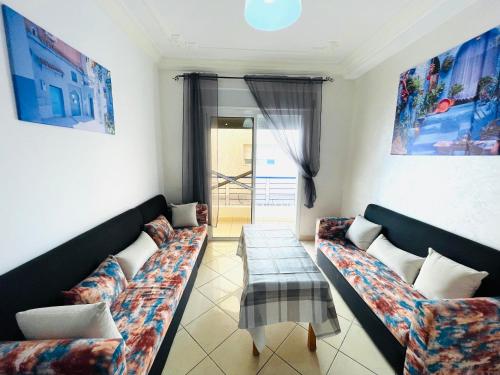 a living room with two couches and a table at Oasis by Azur spacieux proche de la plage in Oued Laou