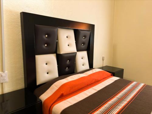 a bedroom with a bed with an orange blanket at Casa Elim-Oaxaca in Teotitlán del Valle