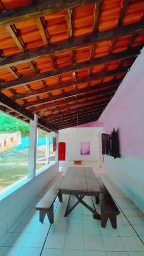 a room with a wooden table and a bench at Renovo Beija-flor Hostel e Espaço Terapêutico in Bertioga