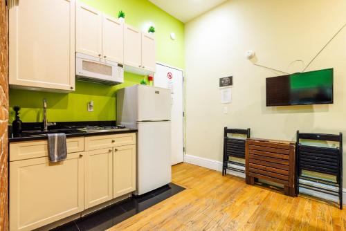 a kitchen with a white refrigerator in a room at Studios in New York in New York