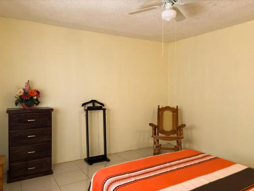 a bedroom with a bed and a dresser and a ceiling fan at Casa Elim-Oaxaca in Teotitlán del Valle