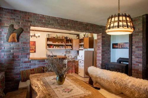 a living room with a table and a brick wall at Secluded holiday house Marija Gorica, Prigorje - 23083 in Marija Gorica