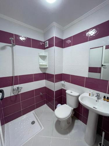 - une salle de bains violette et blanche avec toilettes et lavabo dans l'établissement Oasis spacieux proche de la plage, à Oued Laou