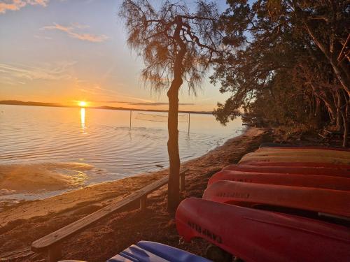 a sunset on the shore of a body of water at Camp Elim in Forster