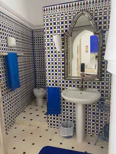 a bathroom with a sink and a mirror at Grande demeure de charme in Asilah