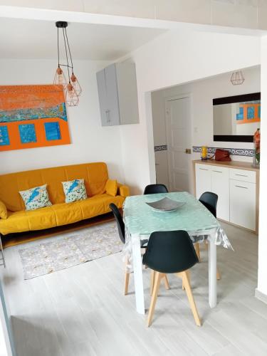 sala de estar con mesa y sofá amarillo en Carolina do Mar, en Nazaré