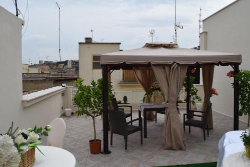 cenador en un balcón con mesa y sillas en DomuS al Corso con servizio B&B, en Canosa di Puglia