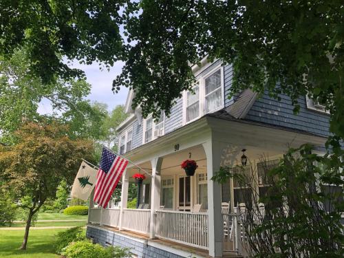 ein Haus mit amerikanischer Flagge auf der Veranda in der Unterkunft The Harbor Inn in Kennebunkport