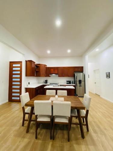 a kitchen with a wooden table and white chairs at Casa Nefertari I in Flores