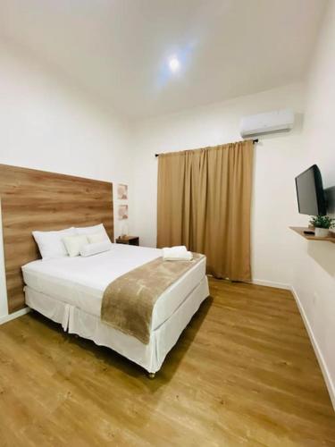a bedroom with a large white bed and a television at Casa Nefertari I in Flores