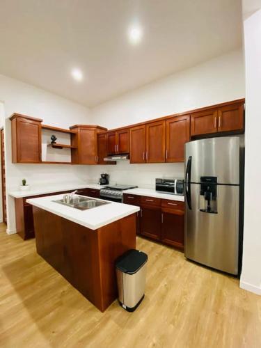 a kitchen with wooden cabinets and a stainless steel refrigerator at Casa Nefertari I in Flores