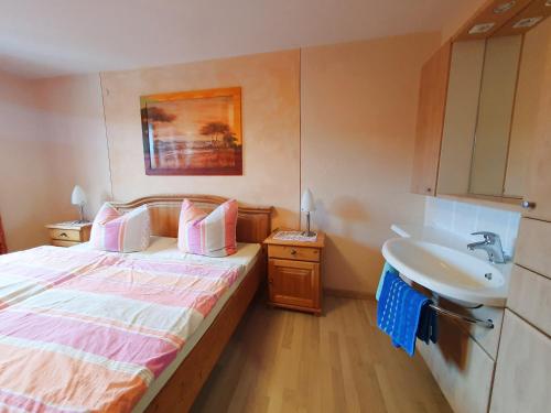 1 dormitorio con 1 cama y lavamanos. en Dwingelo-Lütten Angela Brandstätter Hof | Chiemgau Karte, en Grassau