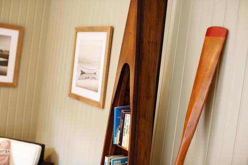 a wooden book shelf with a mirror on a wall at Hotell Uddewalla in Uddevalla