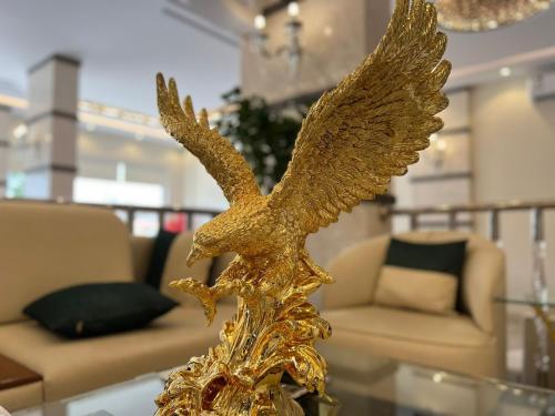 a gold eagle statue on a glass table in a living room at شقق سطام المخدومة in Al Fayşalīyah