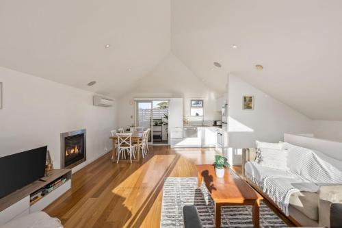 a white living room with a couch and a table at Townhouse on King in Queenscliff