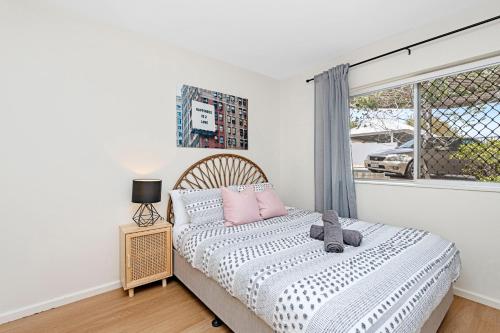 a bedroom with a bed with pink pillows and a window at 4 Cute Cunningham Close To Subiaco - Sleeps 4 in Perth