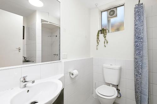 a white bathroom with a toilet and a sink at 4 Cute Cunningham Close To Subiaco - Sleeps 4 in Perth