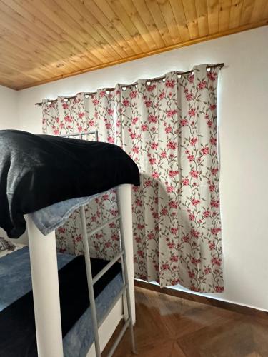 a bedroom with a window with a curtain at Finca Siberia, Sisga in Tilatá
