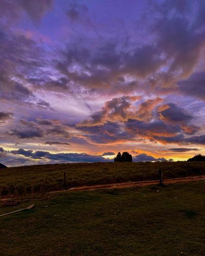 a sunset in a field with a cloudy sky at Finca Siberia, Sisga in Tilatá