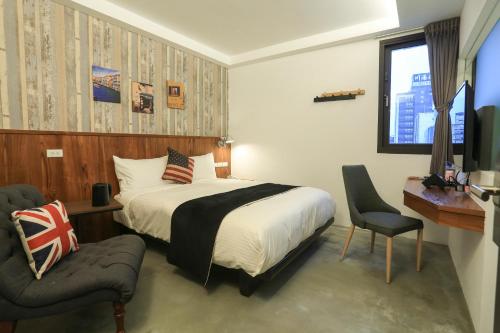 礁溪鄉的住宿－沐谷親子溫泉會館，一间卧室配有一张床、一把椅子和电视