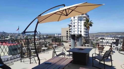 a patio with a table and chairs and an umbrella at Cabaña DW in Tijuana